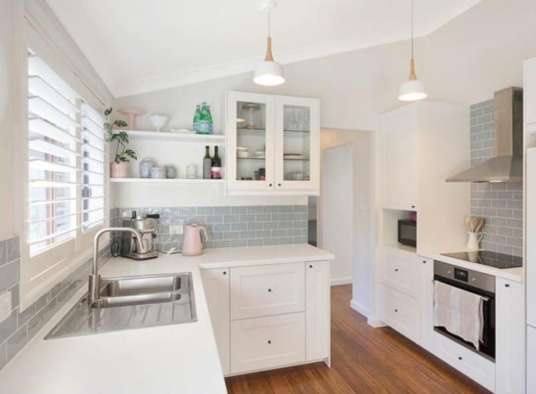 A clean white kitchen with grey subway tiles